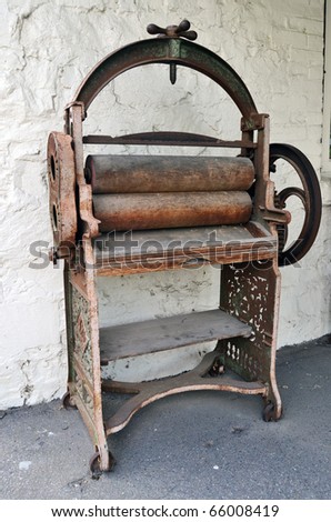 A rusty old hand operated printing press machine.