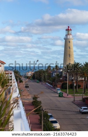 View from the balcony to a narrow street, a tall lighthouse and the ocean in Punta del Este, Uruguay Foto stock © 