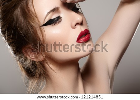Close-up portrait of sexy caucasian young woman model with glamour red lips make-up, eye arrow makeup, purity complexion. Perfect clean skin.