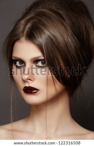 Fashion model with tousled hair, make-up. Portrait of young fashion woman with punk rock hairstyle, dark make-up