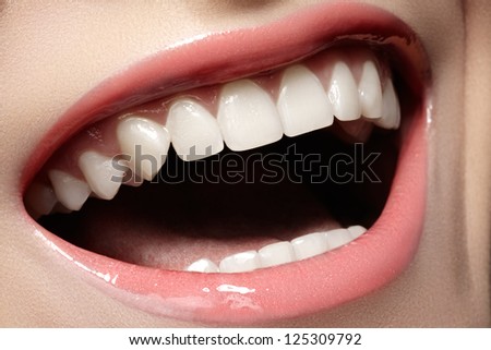 Macro happy woman\'s smile with healthy white teeth, tender pink gloss lips make-up. Stomatology and beauty care