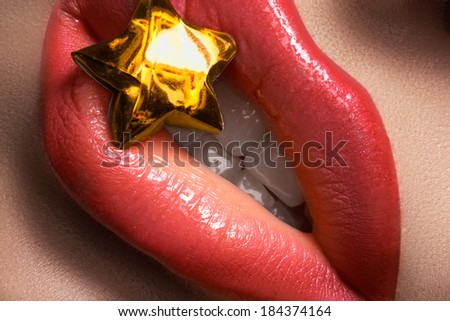 Bright lip make-up on woman\'s lips. Close-up of beautiful coral lips makeup. Beauty macro shot of female mouth with gold lucky star. Perfect fashion visage for holidays
