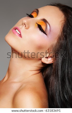 Portrait of sensual woman model with arabic bright make-up, long volume black hair. Fashion colorful hairstyle. Beautiful female face.