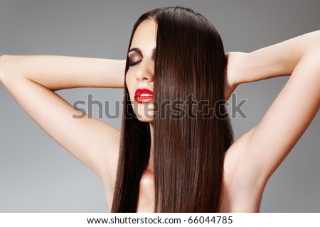 Haircare, cosmetics and make-up. Beauty care. Relaxing. Portrait of woman with shiny slicked hairstyle on gray background.
