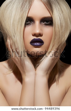 Punk rock style or halloween make-up. Fashion woman model face with bright glamour makeup. Perfect skin, black gloss eyeshadows on eyes and dark violet glossy lips visage.