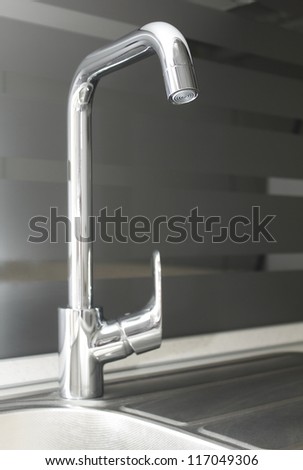 The picture shows a chrome kitchen faucet
