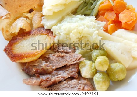 Traditional English sunday roast lamb dinner with yorkshire pudding and fresh garden vegetables, macro