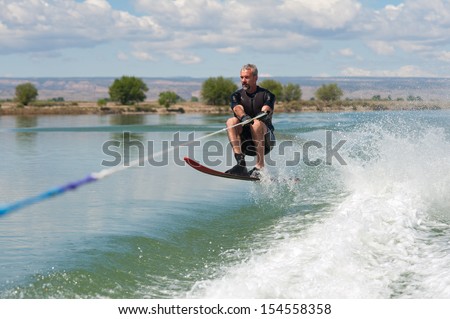 A 50 yr. old man jumps the wake as he slalom waterskis on Sweitzer Lake in Delta, Colorado.