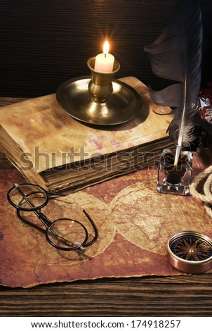 ancient books with candle and Compass on the old paper background