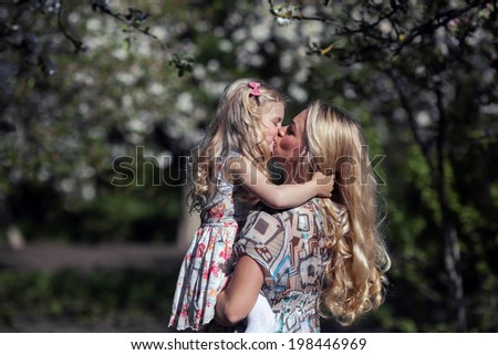 daughter kisses mom in the garden