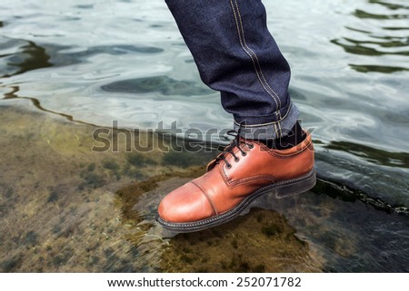 Feet of of Men dressed in selvedge jeans , retro shoes and plaid shirt. Vintage look