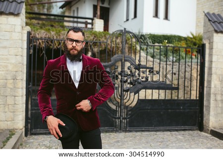 a rich man in a jacket near his house