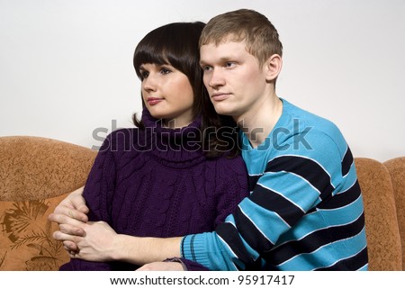 the guy hugging a girl, sitting on the couch
