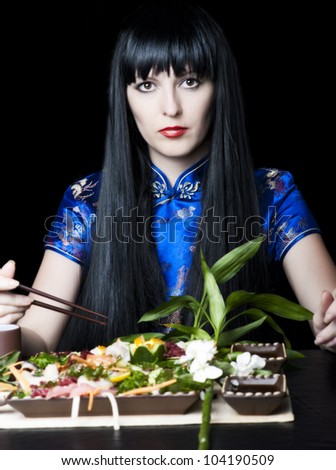 Black-haired girl with a chopsticks in japan restaurant