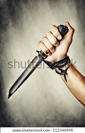 male hand holding combat black Knife