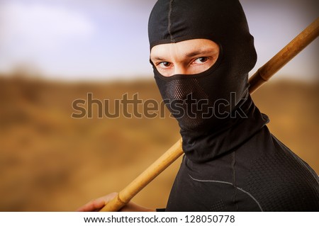 Close up portrait of male ninja in black mask covered his face