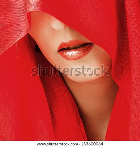 Portrait of sensual woman model with sexy makeup on lips and covered eyes by red  scarf