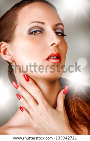 Young woman with long false lashes, fashion red nails and sensual lips - Model posing in studio