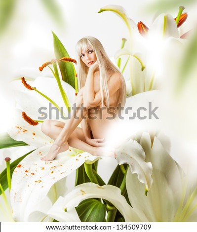 Sexy woman pixie sitting on white lily in fantasy magic world