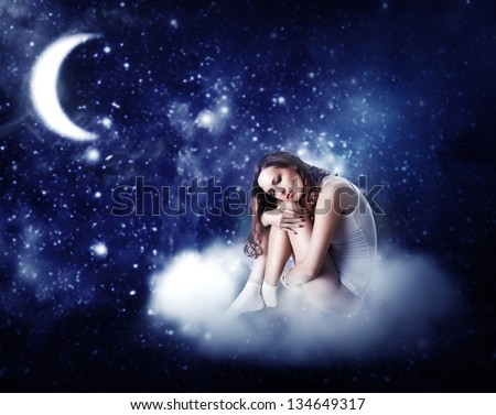young beautiful woman sleeping on a fairy cloud  in a starry night sky in the moonlight