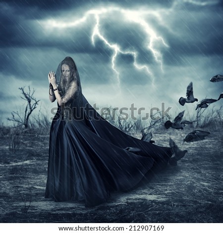 Fantasy world - beautiful woman in black fashionable medieval dress and pigeon birds