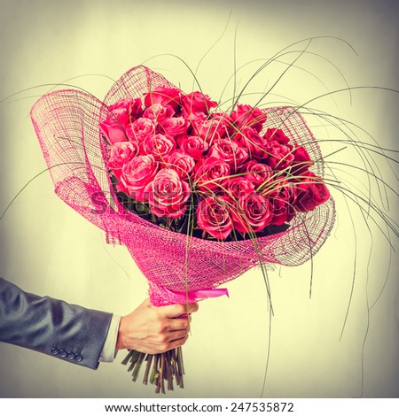 Big beautiful bunch of flowers - red roses in male hand. Valentines day in retro style