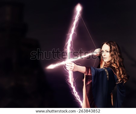 Beautiful fairy woman archer with a magic bow at night on dark background