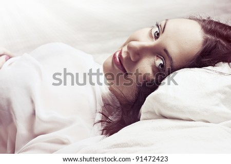 Lovely face of sexy female model in light bedroom in the morning