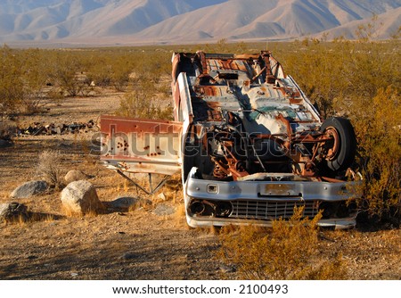 Deserted wrecked car in the desert with bullet holes in the door