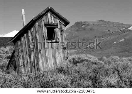 Black and white image of an old weathered deserted shack in deserted California mining town