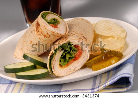 A turkey and swiss cheese wrap with chips and soft drink