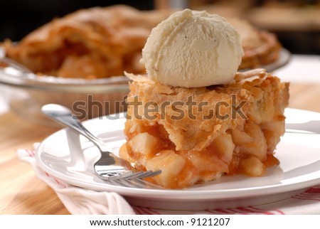 A piece of freshly made deep dish apple pie with a flaky crust and vanilla ice cream