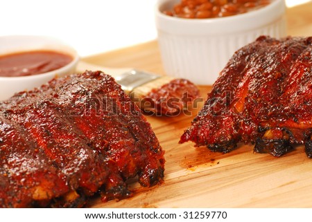 Slab of BBQ spare ribs with beans and dipping sauce