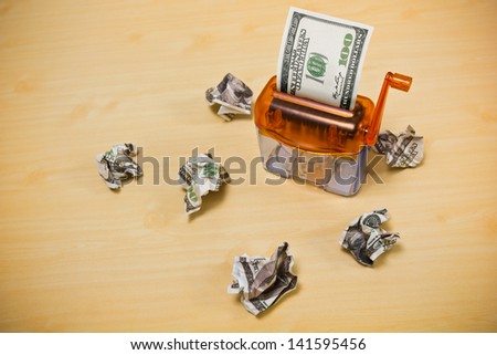 Dollar banknote in a paper shredder portrays  decreasing value of  money