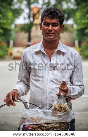 BANGKOK, THAILAND - SEPTEMBER 7: Indian man on September 7, 2013. Young expat Indian man travels across the sea from Mumbai to be a street vendor by selling peanuts with his bike in Thailand.