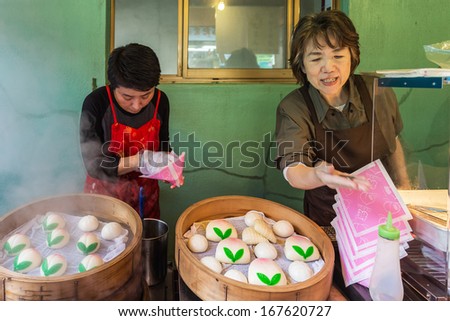 Nagasaki, Japan - November 14 2013: Unidentified Chinese Bun shop in keeper Chinatown steams her buns in chinese traditional bamboo steaming pot