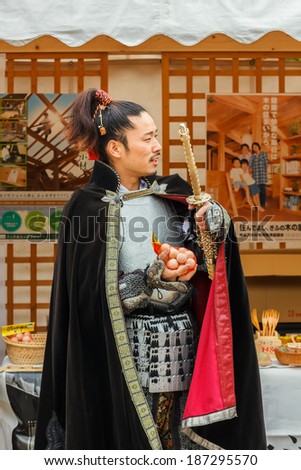 NAGOYA, JAPAN - NOVEMBER 21: Japanese Fair in Nagoya, Japan on November 21, 2013. Japanese vendor dresses old style warrior costume to promote his product at Nagoya Castle Fair