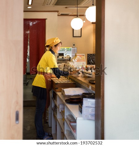 KAMAKURA, JAPAN - NOVEMBER 24: Japanese sweet shop in Kamakura, Japan on November 24, 2013. Unidentified female shop keeper sell her sweet to a customer