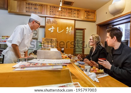 TOKYO, JAPAN - NOVEMBER 25: Japanese Sushi Chef  in Tokyo, Japan on November 25, 2013. Unidentified Japanese Sushi Chef prepares a dish of sushi for his customer