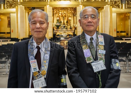 TOKYO, JAPAN - NOVEMBER 25: Tsukiji Honganji Temple in Tokyo, Japan on November 25, 2013. Japanese Senior usher can be found to give information and help people in the temple