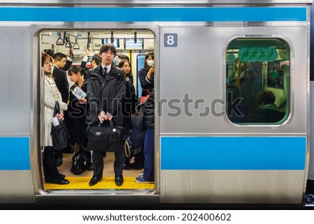 TOKYO, JAPAN - NOVEMBER 26: Train Commuters in Tokyo, Japan on November 26, 2013. Tokyo train is always packed with people all through the day and especially in rush hours