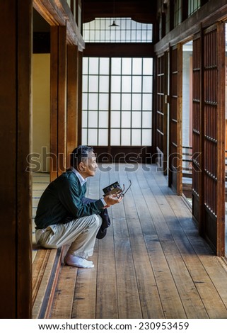 KYOTO, JAPAN - OCTOBER 20: Kennin-ji Temple in Kyoto, Japan on October 20, 2014. Unidentified man look at a Zen garden in Kennin-ji Temple ground