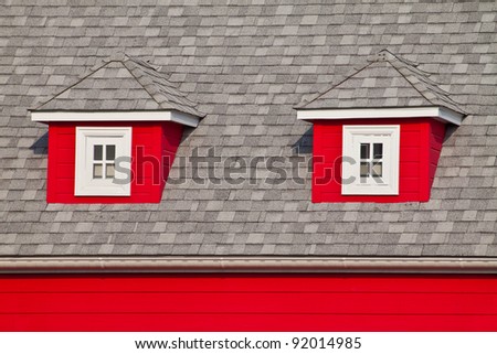 Small Windows of an Attic on The Roof of a Red House