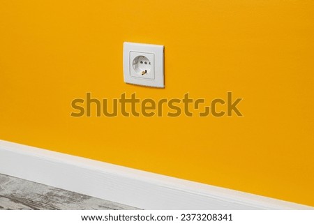 Yellow outlet installed on the white wall, side view. Сток-фото © 