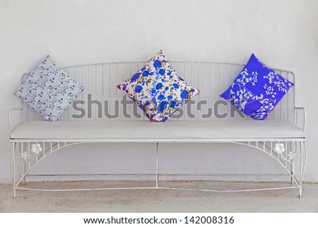 Blue pillow on the white chair.