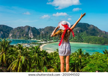 The girl at the resort in a dress and hat on the background of the bays of the island of Phi Phi