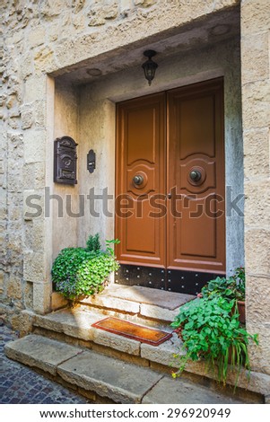Windows and doors in an old house decorated with flower pots and flowers