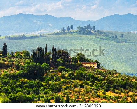 rural landscape with houses standing alone in the province of Tuscany in Italy