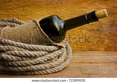 bottle wrapped with rope against a wooden board