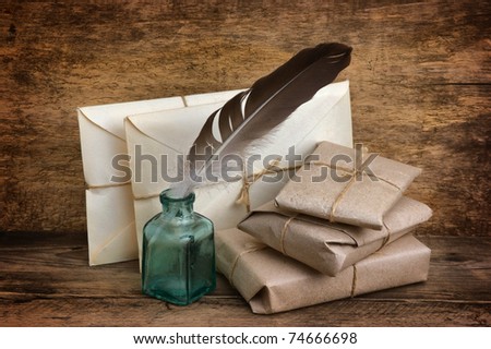 Postage on the background of an old wooden board with a pen for writing in the ink